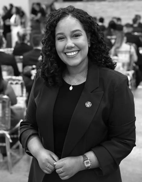 Carolyne Partata, advogada, sorrindo, de blazer escuro